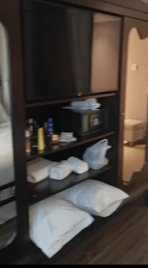 Buona Vitta Gramado Resort & Spa By Gramado Parks Экстерьер фото The photo shows a piece of furniture, likely a shelving unit or cabinet, with several items on it. There is a television mounted on top. Below the TV, there is a microwave and a small safe. The shelves contain various toiletries and personal care pro