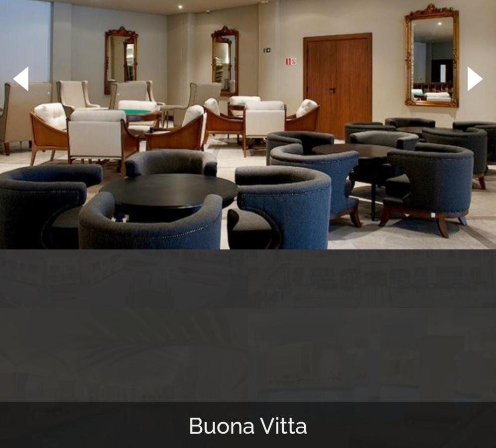 Buona Vitta Gramado Resort & Spa By Gramado Parks Экстерьер фото The photo shows a modern, elegantly designed lounge or waiting area. It features several circular seating arrangements with dark blue armchairs surrounding black tables. In the background, there are light-colored lounge chairs and a wooden door leadi
