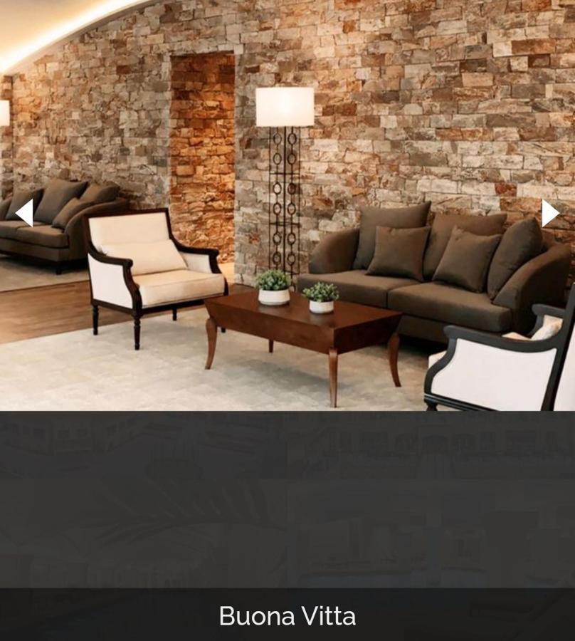 Buona Vitta Gramado Resort & Spa By Gramado Parks Экстерьер фото The image shows a stylish living room setting. There are two sofas: one is a dark brown color, and the other is a cream color with dark wooden accents. In the center, there is a wooden coffee table with a smooth finish and decorative plants on top. T