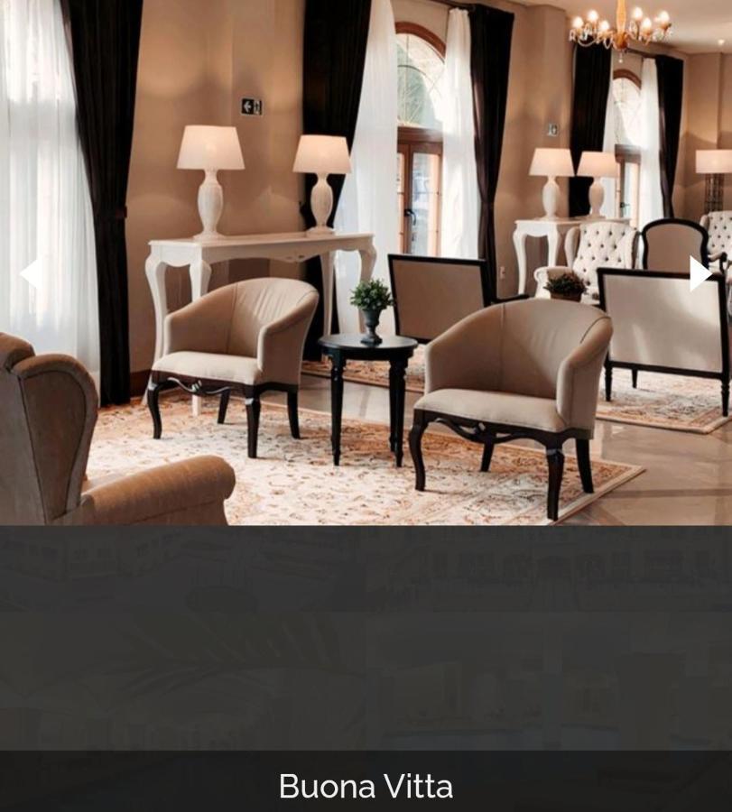 Buona Vitta Gramado Resort & Spa By Gramado Parks Экстерьер фото The photo shows a stylish and inviting interior space, likely a lounge or waiting area. There are beige upholstered armchairs arranged around a small black table. A decorative plant is placed on the table. Behind the chairs are light-colored walls wi