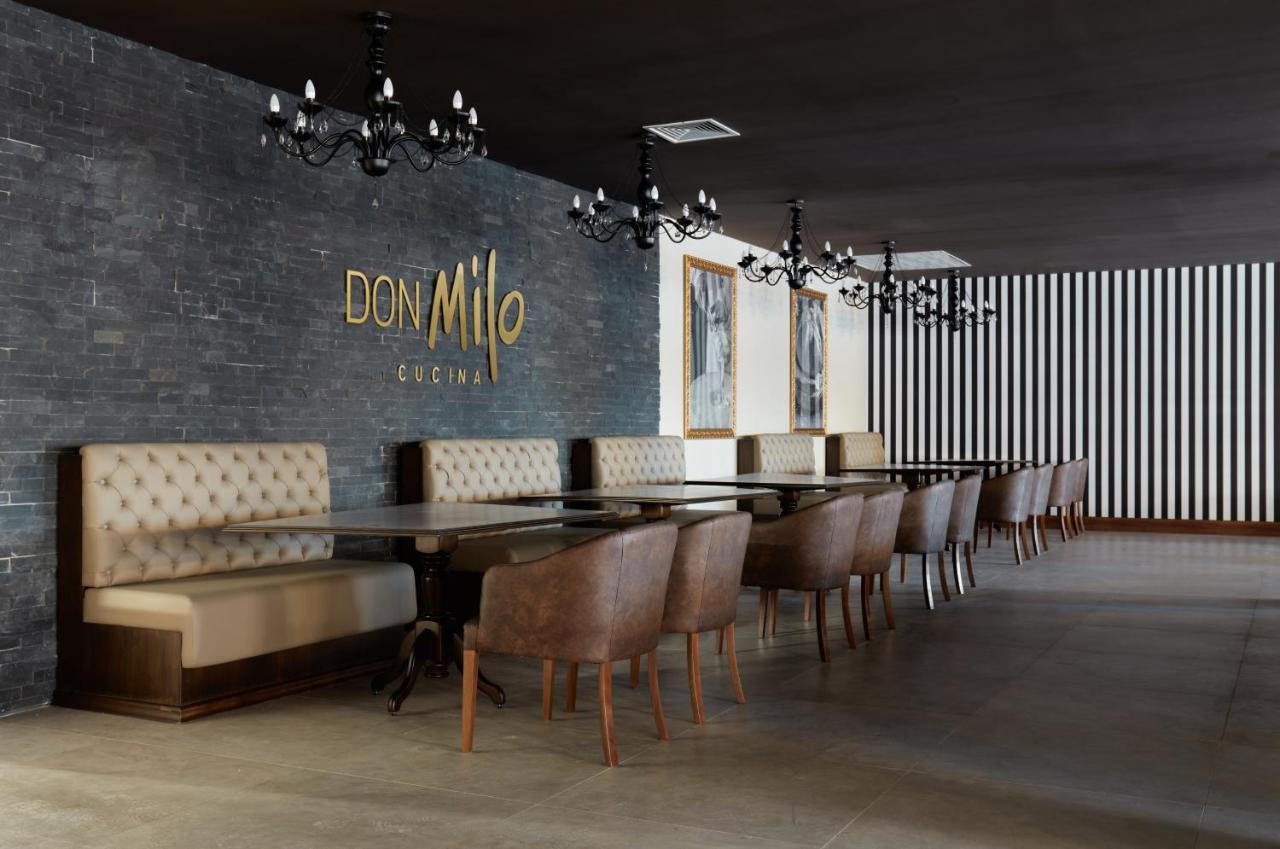 Buona Vitta Gramado Resort & Spa By Gramado Parks Экстерьер фото The photo showcases an interior of a restaurant named "Don Milo." The design features a modern and sophisticated look with a mix of textures and colors. 

On one side, there are upholstered booths in a neutral tone, creating a comfortable dining area