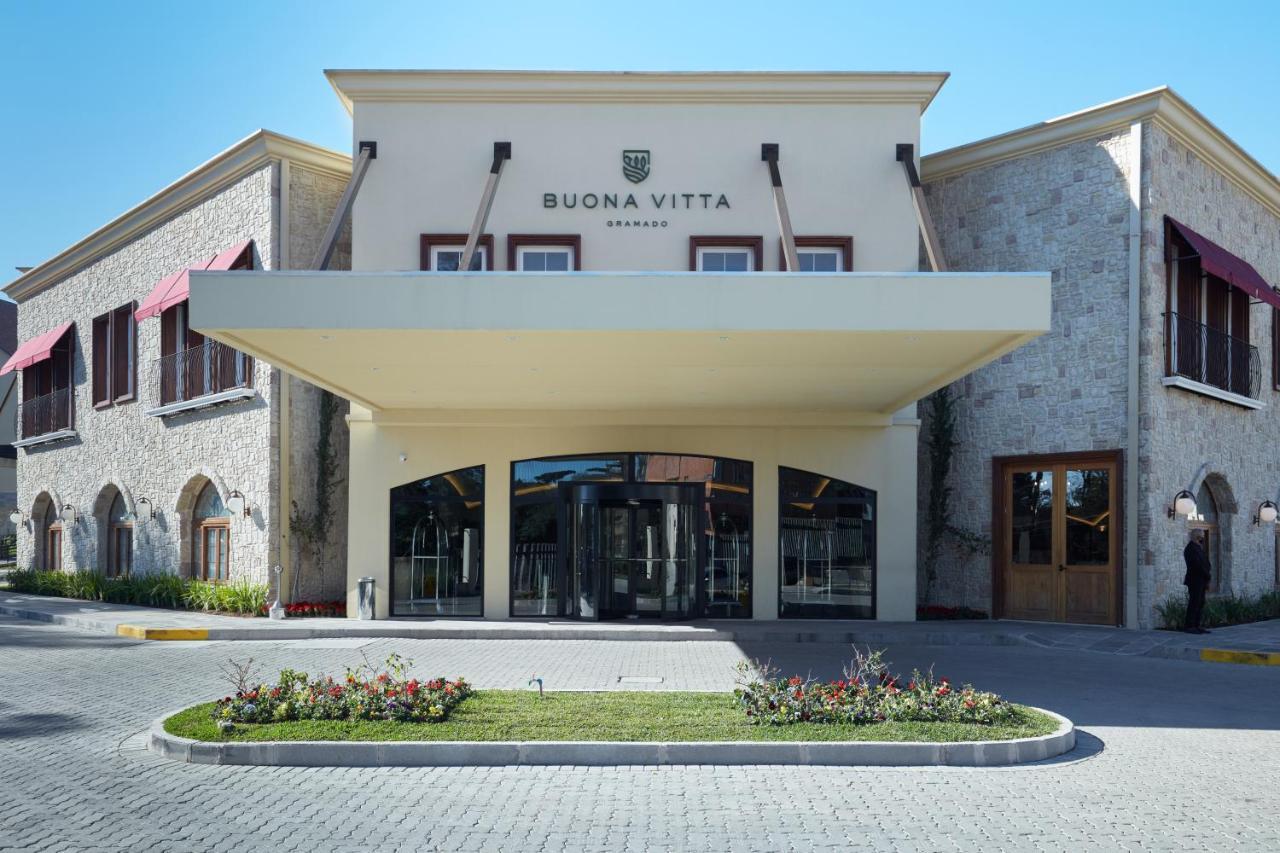 Buona Vitta Gramado Resort & Spa By Gramado Parks Экстерьер фото The photo shows a modern building with a prominent entrance marked by a large awning. The facade features a mix of stone and stucco materials, giving it an elegant and contemporary look. The name "BUONA VITTA" is displayed prominently above the entra