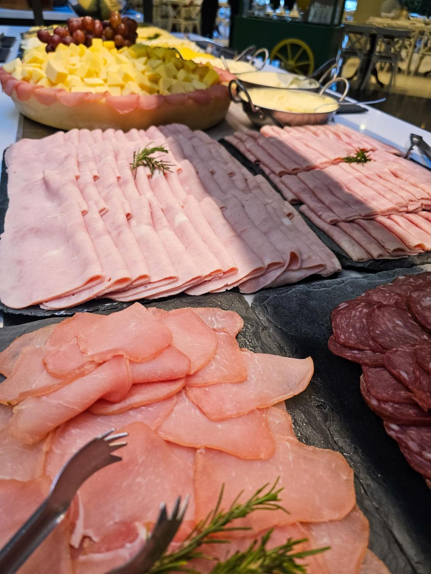 Buona Vitta Gramado Resort & Spa By Gramado Parks Экстерьер фото The photo shows a display of various types of sliced deli meats arranged on a flat surface. There are several layers of thinly sliced, pale-colored meats, likely including ham or turkey, organized neatly in parallel rows. Additionally, there are slic